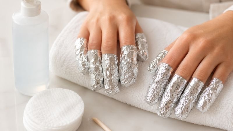 Fingernails wrapped in foil with cotton pads soaked in acetone for gel removal