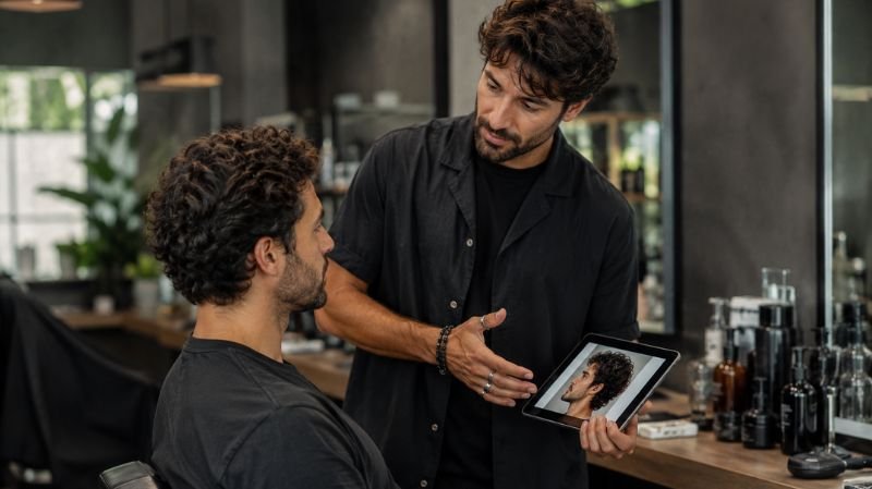 Man discussing wavy haircut with barber