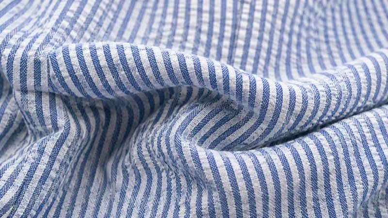 Close-up of blue and white seersucker fabric with a raised puckered texture