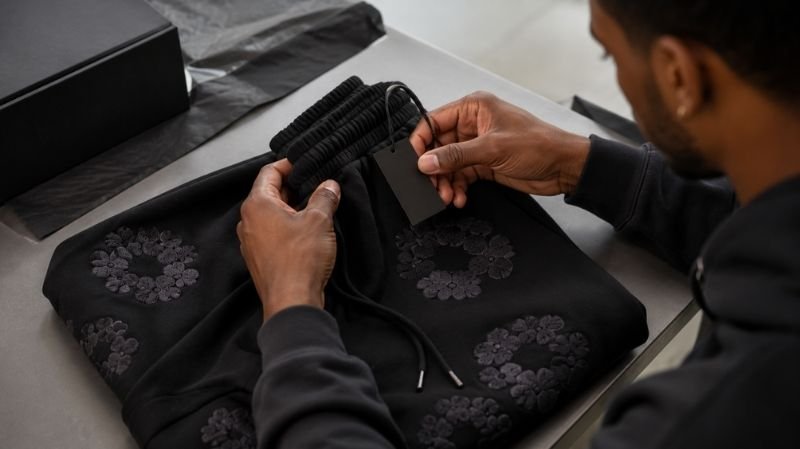 Denim Tears Sweatpants: Styles, Fit, Sizing & Buying Guide Denim Tears sweatpants tags and product details being checked for authenticity